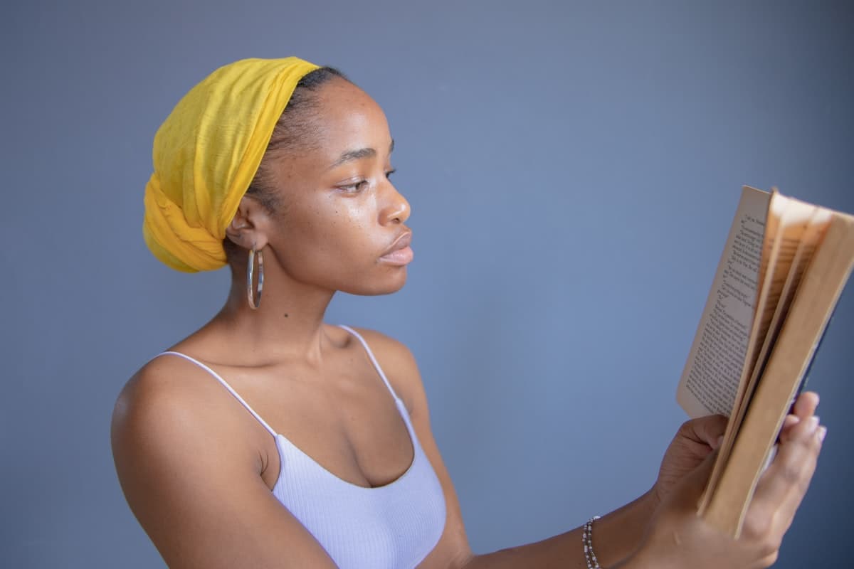 A woman in a yellow hijab reading calmly — clarity and guidance